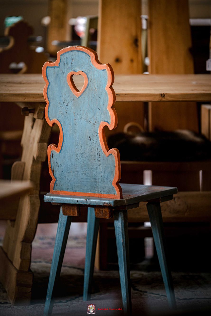 Sedia in legno azzurra con bordo arancione e cuore traforato nello schienale